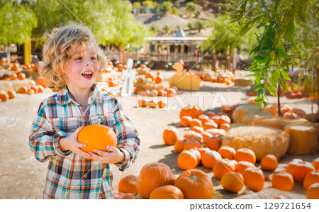 Cute Young Boy Having Fun at the Pumpkin Patch on a Sunny Fall Day. 129721654