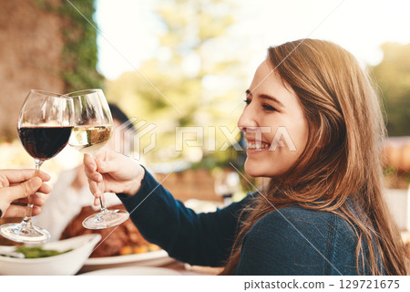 Wine toast, glasses and celebration dinner party with a woman happy about holiday event. Food, happiness and christmas lunch of female cheers with alcohol drink to celebrate gratitude outdoor 129721675