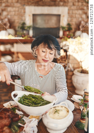Thanksgiving table and senior woman with vegetables serving at food party for USA celebration. Holiday, celebrate and mature festive person at home dining table with green beans for nutrition. Thanksgiving table and senior woman with vegetables serving at food party for USA celebration. Holiday, celebrate and mature festive person at home dining table with green beans for nutrition. 129721738