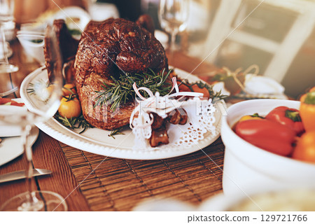 Thanksgiving, food and roast meat for dinner on a dining table at a party, celebration or event. Christmas, chicken and luxury meal or feast at a festive holiday banquet to celebrate xmas at a house. 129721766