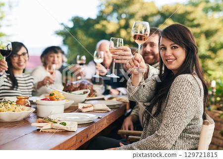 Toast, dinner and family with a group of people enjoying a meal together while drinking alcohol outdoor. Portrait, party and cheers with a female and relatives bonding in festive celebration Toast, dinner and family with a group of people enjoying a meal together while drinking alcohol outdoor. Portrait, party and cheers with a female and relatives bonding in festive celebration 129721815