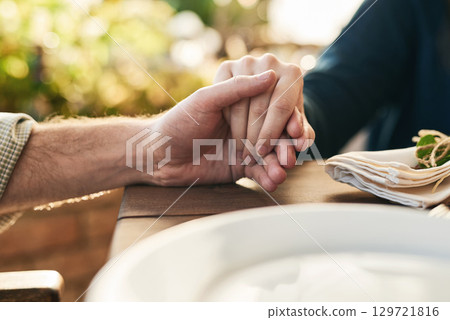 Couple, holding hands and lunch with praying, love and trust in marriage, hope and care at table outdoor. Man, woman and hand for hope, gratitude and prayer in Christian faith, spiritual or support 129721816