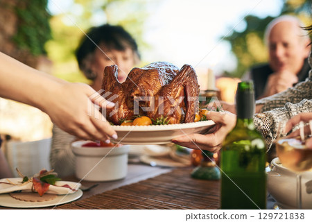 Thanksgiving, turkey and hands with a family eating a meal outdoor together in celebration of tradition. Christmas, chicken and party with a man and woman group enjoying dinner while bonding Thanksgiving, turkey and hands with a family eating a meal outdoor together in celebration of tradition. Christmas, chicken and party with a man and woman group enjoying dinner while bonding 129721838