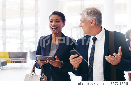 Business black woman and man talking, walking and in office for planning together. Coworkers, female manager and male employee have conversation, tablet and smartphone for discussion and strategy. Business black woman and man talking, walking and in office for planning together. Coworkers, female manager and male employee have conversation, tablet and smartphone for discussion and strategy. 129721896