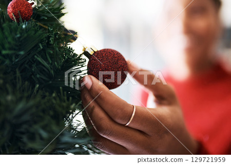 Hand, decoration with Christmas ornament and tree, holiday celebration zoom with festive tradition. Red, glitter sphere for Christmas tree with decorating closeup and celebrate with bauble at home Hand, decoration with Christmas ornament and tree, holiday celebration zoom with festive tradition. Red, glitter sphere for Christmas tree with decorating closeup and celebrate with bauble at home 129721959