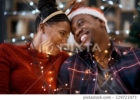 Couple, christmas celebration and festive holiday, lights and happy smile, hat and love together with home decoration. Black man, woman or happiness for xmas in house, celebrate or enjoy with partner 129721973