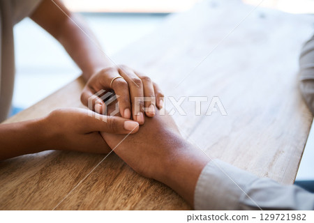 Couple, holding hands and support on table in closeup for help, care and empathy in time of grief. Black couple, helping hand and love to forgive, consult or comfort together in home with kindness 129721982
