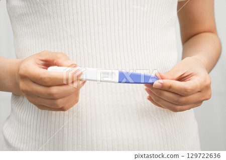 Asian holding pregnancy test for female of ovulation day, fetus, maternity, childbirth, birth control. 129722636