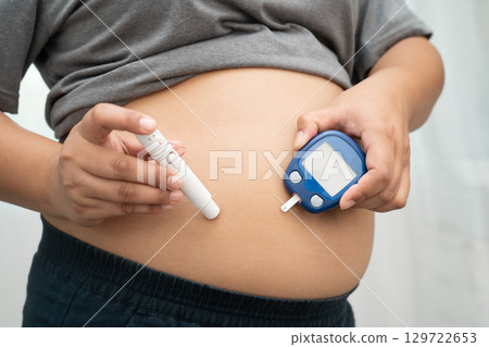 Asian woman injecting herself diabetes injecting insulin in stomach at home. Asian woman injecting herself diabetes injecting insulin in stomach at home. 129722653