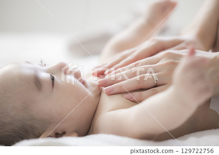 年輕的母親照顧她的孩子 年輕的母親照顧她的孩子 129722756