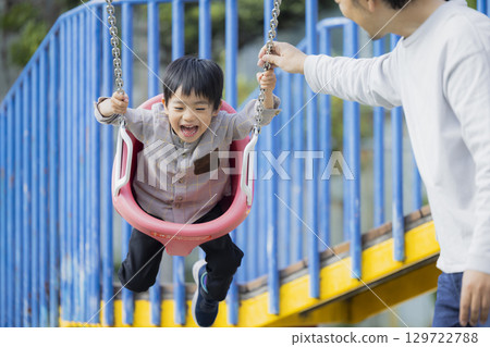 Parent and child playing in the park Parent and child playing in the park 129722788