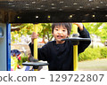 Smiling elementary school child playing on playground equipment in the park Asian Japanese 129722807