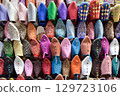 Front view of Slippers or sandals of many colors hung from street stalls 129723106