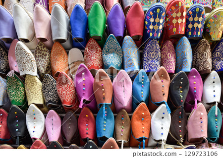 Front view of Slippers or sandals of many colors hung from street stalls 129723106