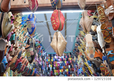 Slippers or sandals of many colors hung from street stalls in Marrakech's souk Slippers or sandals of many colors hung from street stalls in Marrakech's souk 129723108
