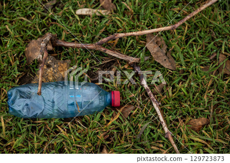 plastic empty bottle of water lies on the ground 129723873