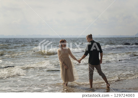 lovers and romantic newlyweds having fun on the seashore. 129724003