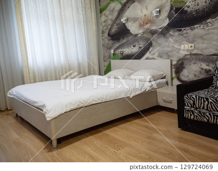 Double bed with pillows and light from the window. Double bed with pillows and light from the window. 129724069