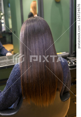 In a beauty salon, a girl's hair is being dried with a hairdryer In a beauty salon, a girl's hair is being dried with a hairdryer 129724076