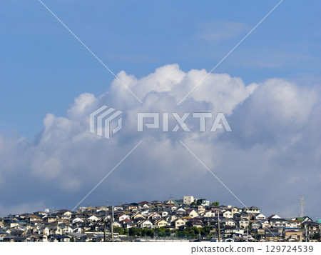 Cumulonimbus clouds in the summer sky and residential areas on high ground 129724539