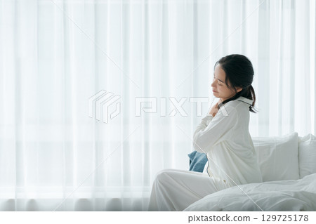 A woman waking up with a tired look 129725178