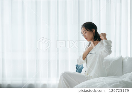 A woman waking up with a tired look A woman waking up with a tired look 129725179