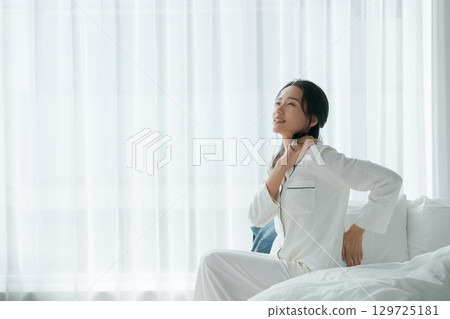 A woman waking up with a tired look 129725181