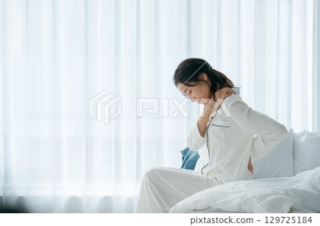 A woman waking up with a tired look A woman waking up with a tired look 129725184