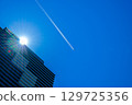 一架客機和尾跡飛過一棟高層公寓大樓 129725356