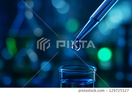 AI generated close up of a clear liquid droplet at the tip of a pipette with blurred blue and green laboratory background symbolizing precision and scientific innovation AI generated close up of a clear liquid droplet at the tip of a pipette with blurred blue and green laboratory background symbolizing precision and scientific innovation 129725527