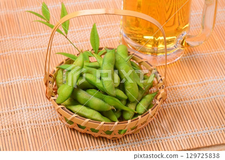 A classic summer snack: edamame (green soybeans), green soybeans, and draft beer. A classic summer snack: edamame (green soybeans), green soybeans, and draft beer. 129725838