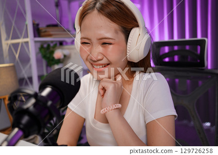 Podcast host recording professional audio for streaming broadcast and digital content creation in modern studio 129726258