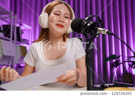 Podcast host recording professional audio for streaming broadcast and digital content creation in modern studio Podcast host recording professional audio for streaming broadcast and digital content creation in modern studio 129726265