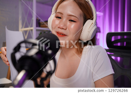 Podcast host recording professional audio for streaming broadcast and digital content creation in modern studio Podcast host recording professional audio for streaming broadcast and digital content creation in modern studio 129726266