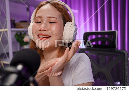 Podcast host recording professional audio for streaming broadcast and digital content creation in modern studio Podcast host recording professional audio for streaming broadcast and digital content creation in modern studio 129726275