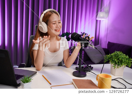 Podcast host recording professional audio for streaming broadcast and digital content creation in modern studio 129726277