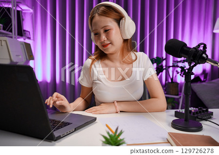 Podcast host recording professional audio for streaming broadcast and digital content creation in modern studio 129726278