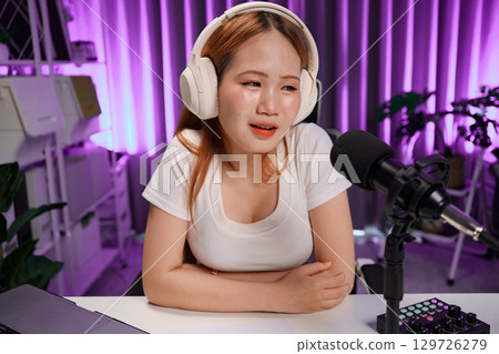 Podcast host recording professional audio for streaming broadcast and digital content creation in modern studio Podcast host recording professional audio for streaming broadcast and digital content creation in modern studio 129726279