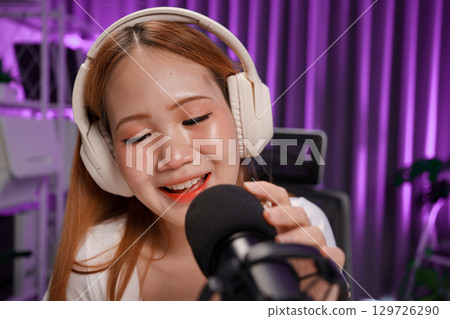 Podcast host recording professional audio for streaming broadcast and digital content creation in modern studio 129726290
