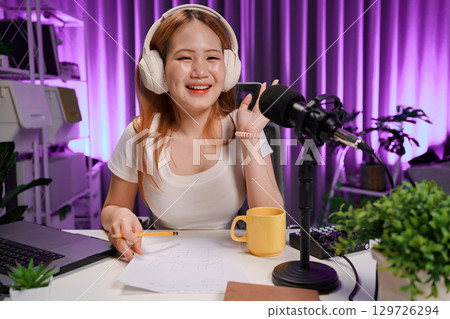 Podcast host recording professional audio for streaming broadcast and digital content creation in modern studio Podcast host recording professional audio for streaming broadcast and digital content creation in modern studio 129726294