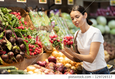 woman chooses a red radish woman chooses a red radish 129726517