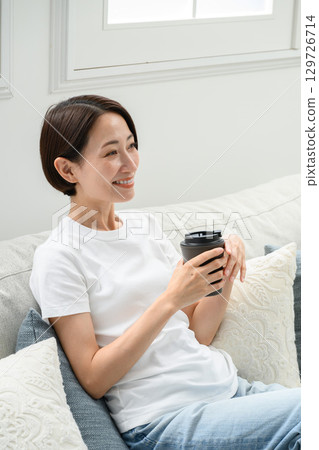 A woman drinking coffee at home 129726714