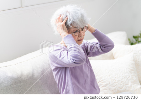 Senior woman sitting on sofa Senior woman sitting on sofa 129726730