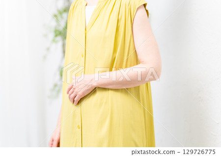 穿著黃色禮服的資深婦女 穿著黃色禮服的資深婦女 129726775