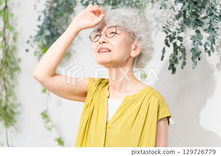 Senior woman wearing a yellow dress Senior woman wearing a yellow dress 129726779