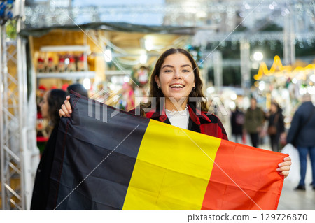 Womav waving of the Belgian flag at New Year street fair 129726870