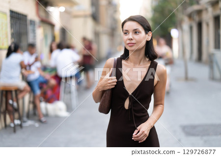 Woman walks along narrow street between buildings of 19th century Woman walks along narrow street between buildings of 19th century 129726877