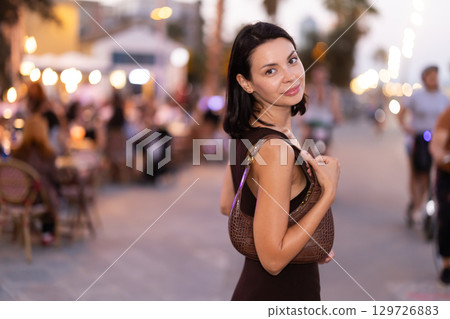 Young woman walking on a lively promenade of Barceloneta 129726883