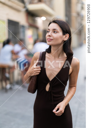 Young woman walks along narrow street in old Barcelona 129726908
