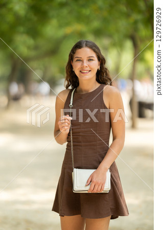 Woman walking in the park in summer 129726929